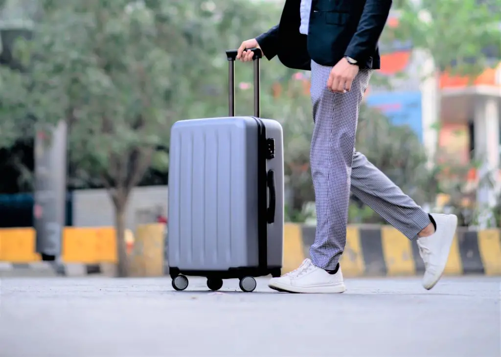 person pushing a small suitcase