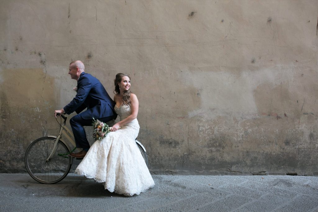 bride and groom riding bicycle in florence italy