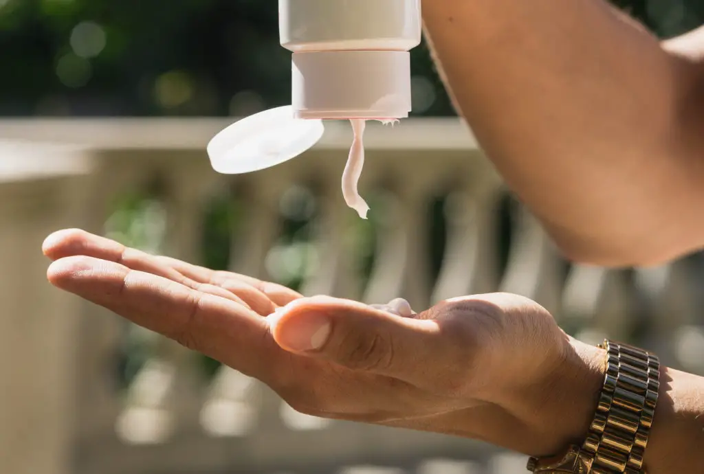 person applying lotion to a tan