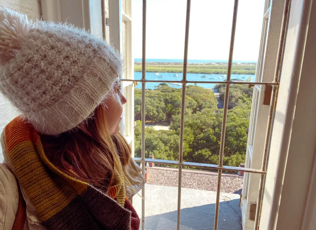 woman looking out the window from the top of St.  Augustine lighthouse
